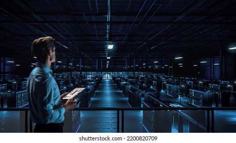 IT Specialist Uses Tablet Computer in Data Center Room. Server Farm Cloud Computing Facility with Maintenance Administrator Working. Cyber Security Engineer Working in Network Protection. - Powered by Shutterstock