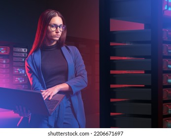 IT specialist woman. Girl with laptop in server room. Woman works as system administrator. Young businesswoman next to servers. IT business owner concept. IT company employee and server hardware