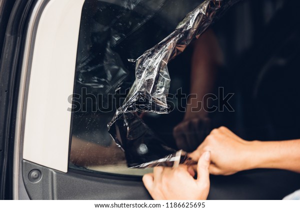 Specialist worker service peeling old film from\
window car