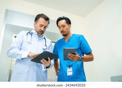 Specialized doctor medical center and hospital health care services. Group of doctor and nurse talking discussion about surgical and patient care during waiting for elevator in hospital corridor. - Powered by Shutterstock