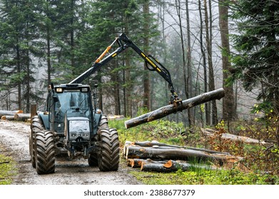 A specialized forest tractor working with logging in the rain in the Carpathians, Poland. - Powered by Shutterstock