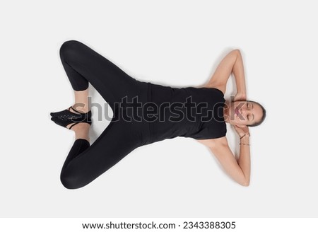 Specialized trauma releasing exercises for elderly people, 55 years old woman trainer posing for exercises. Activation pose, top down view, in the studio isolated on white