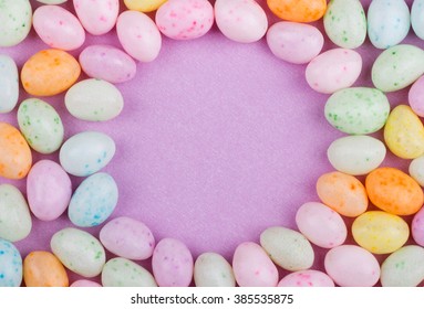 Speckled Easter Jelly Bean Border Around A Purple Background With Copy Space