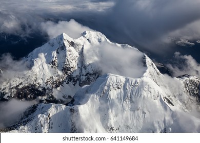 Spectacular aerial landscape view of the mountains covered by the layer of cumulus clouds. Taken near Sunshine Coast, British Columbia, Canada.
