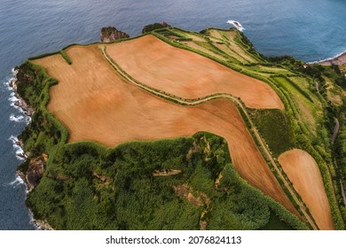 Spectacular drone view of sandy fields on rocky cliff located near sea coast