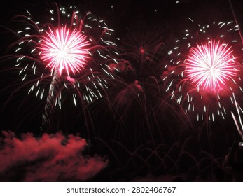 Spectacular fireworks exploding over the Xiying Rainbow Bridge during the Penghu International Fireworks Festival in Taiwan. Long exposure night photography with vibrant ocean reflections.