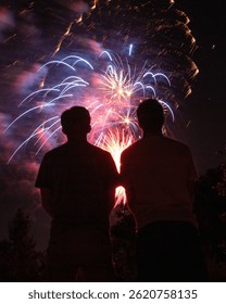 Spectacular Fireworks Exploding Overhead with Silhouetted Figures