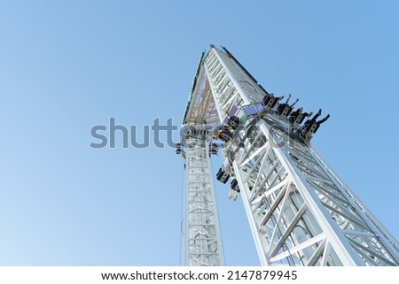 A spectacular free fall attraction in an amusement park, with a large copy space.