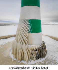 Spectacular ice formations on a lighthouse cold and windy day. Natural phenomenon. Nida town, Lithuania frozen covered by ice after a strong wind