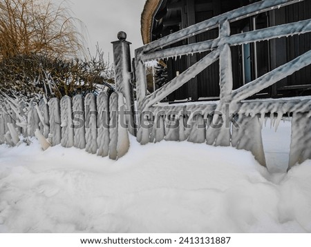 Spectacular ice formations on wooden fence and gates a cold and windy day. Nida town, Lithuania frozen covered by ice after a strong wind