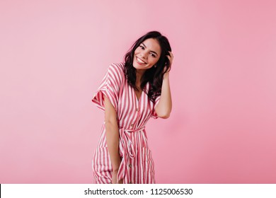 Spectacular Latin Young Woman Playing With Her Brown Hair. Indoor Photo Of Wonderful Female Model Isolated On Pink Background.