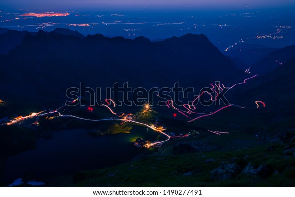 Spectacular mountain road in\
the night, lights on winding road, Transfagarasan road in Romania,\
night scene
