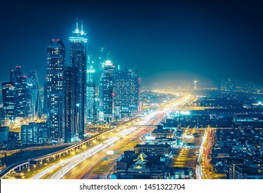 Spectacular Nighttime Skyline Of A Big Modern City At Night.
 Dubai, UAE. Aerial View On Highways And Skyscrapers.