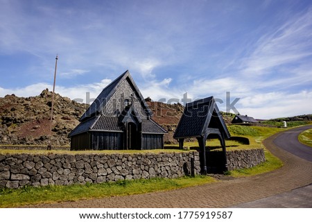 Spectacular Nordic Stave Church in Heimaey, Vestmannaeyjar, Iceland with mountains on the background on a calm summer day.