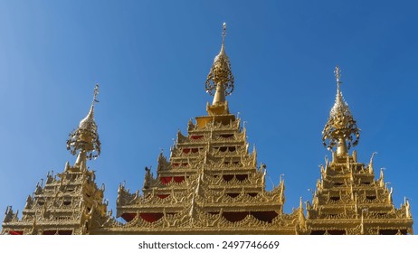 The spectacular roof of the temple against a clear blue sky. Pyramidal golden towers with openwork ornaments and carvings. Peaks on  rooftops. Dhammikarama burmese temple. Malaysia. Penang. Georgetown - Powered by Shutterstock