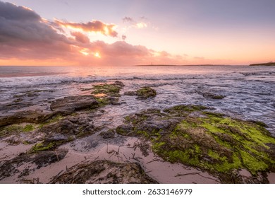 Spectacular Sunset Over Rocky Beach and Illa del Aire Lighthouse in Punta Prima, Menorca. Vibrant sky, ocean waves, rugged coastline, Mediterranean beauty, tranquil scene - Powered by Shutterstock - Get 15% off with code: PIKWIZARD15