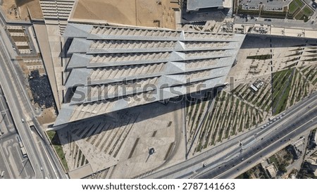 A spectacular top-down bird's-eye view drone photograph of the Grand Egyptian Museum (GEM) in Giza, Egypt, showcasing its modern geometric roof and artistic plaza architecture.