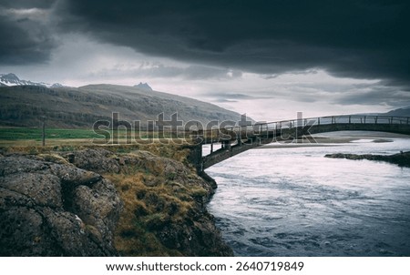 A spectacular vertical view of a bridge arching over a body of water in the East Fjords, Iceland