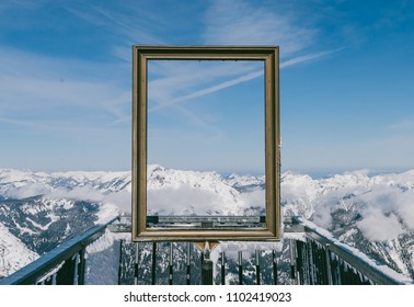 Spectacular view of clear sky and snowy mountain peaks through golden picture frame in Austrian Alps. View from Five Fingers, Obertraun
