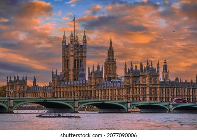 Spectacular view of Parliament buildings and Westminster bridge in front of it at sunset in London, England; small figures of walking people and bus on the bridge - Powered by Shutterstock