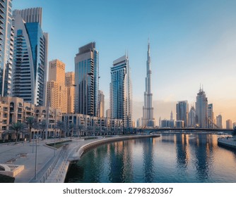A spectacular wide-angle cityscape capturing the hyper-modern, soaring glass skyscrapers of downtown Dubai, United Arab Emirates. The image showcases sleek, ultra-tall corporate towers, architectural marvels, and luxury high-rise residences flanking a pristine, multi-lane urban boulevard. Bathed in the warm, golden light of a desert sunset, the brilliant glass facades reflect the glowing horizon, while manicured palms line the pathways below. This cutting-edge urban center represents ultimate luxury and engineering ambition, making it an exceptional asset for global wealth management brochures, luxury real estate marketing, international travel banners, and modern Middle Eastern lifestyle editorials.