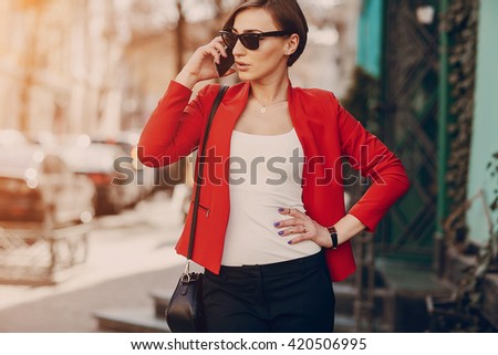 spectacular young brunette outside fashionable and healthy use the phone
