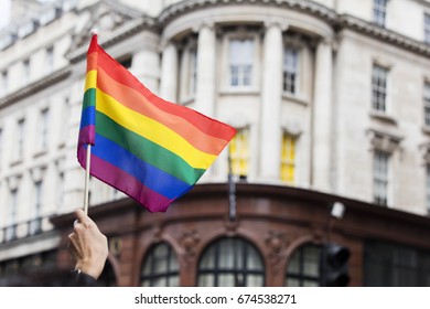 A Spectator Waves A Gay Rainbow Flag At An LGBT Gay Pride March In London