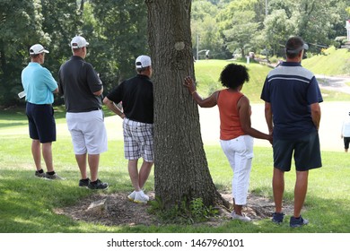 Spectators Stand In Shade To Watch A Golf Tournament