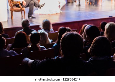 Spectators At A Theater Performance, In A Cinema Or At A Concert. Shooting From Behind. The Audience In The Hall. Silhouettes Of People.