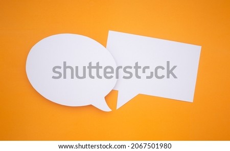 Speech bubble concept. Two empty speech balloons isolated on yellow background with copy space for text. Close-up photo