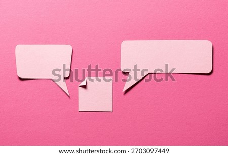 Speech bubbles and paper memo notes with folded dog-ear earmark and copy space for text on pink background, communication dialog concept top view flat lay