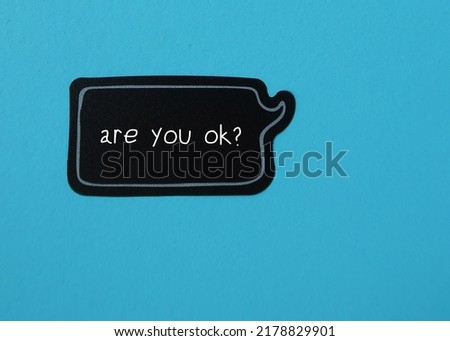 Speech sticker on blue background with handwritten text ARE YOU OK?, to ask question to someone you care to show support and help