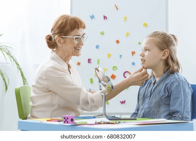 Speech Therapist Exercising With Child In Her Bright Office