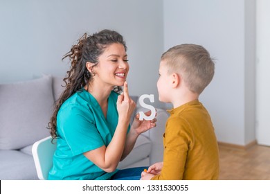 Speech Therapist And Little Patient Training Articulation. Speech Therapist Teaches The Boys To Say The Letter S. Shot Of A Speech Therapist During A Session With A Little Boy 