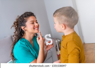 Speech Therapist And Little Patient Training Articulation. Speech Therapist Teaches The Boys To Say The Letter S. Shot Of A Speech Therapist During A Session With A Little Boy 