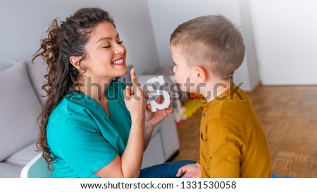 Speech therapist and little patient training articulation. Speech therapist teaches the boys to say the letter S. Shot of a speech therapist during a session with a little boy 