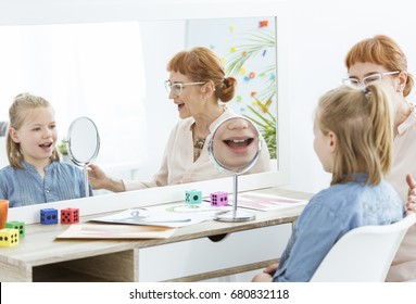 Speech Therapist Using Fun Mirror Exercises During Session With Child