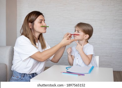 Speech therapy for kids. Young woman and little girl make exercises, activities and game for better speech. - Shutterstock ID 1897565152