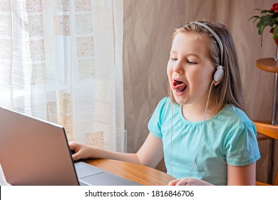 Speech Training Concept. Little Girl Uses A Laptop To Study At Home With A Teacher, A Speech Therapist. Distance Learning. A Kid Doing Exercises For Correct Pronunciation.