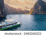 Speed boat on island Ko Phi Phi Lee with paradise lagoon Maya Bay, Thailand, white coral beach, reef with turquoise water.