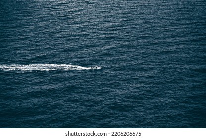 Speed Boat Racing Through A Rough And Cold Sea, Leaving A White Wake Behind It