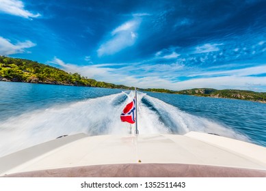 Speed Boat Swiftly Crossing A Sunny Fjord In Southern Norway Sporting The Norwegian Flag. 2017-06-27