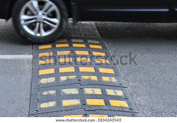 Speed bump on asphalt\
road when and car