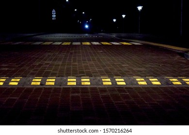 Speed bump in a pedestrian crossing area in the headlights of a car