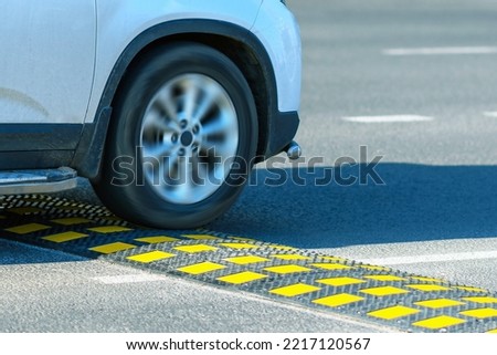 A speed bump in selective focus on the road against the background of a moving car. Speed control.