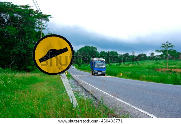 Speed bump sign beside\
asphalt road 