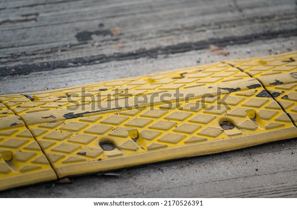 Speed bump which is installed on\
concrete road, using to slowdown the vehicle speed for accident\
prevention. Transportation and trafic safety equipment\
photo.