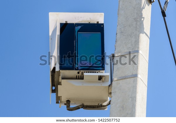 Speed camera car for\
surveillance on highway, tool of police for control road traffic.\
Speed radar cameras mounted on concrete pole against a clear blue\
sky. Speed control.