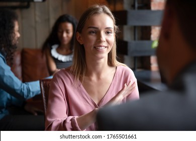 Speed dating, sympathy, flirtation, search partner and love concept. Young woman sitting in cafe participates in matchmaking event activity telling about herself enjoy communication with rear view guy