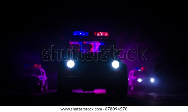 speed lighting of\
police car in the night on the road. Police cars on road moving\
with fog. Selective focus